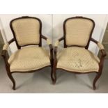 2 gold upholstered wooden framed armchairs.