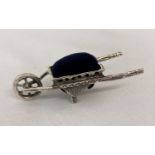 A small 925 silver pin cushion in the form of a wheel barrow, with navy blue velvet cushion.
