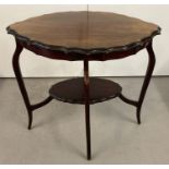 A vintage mahogany oval shaped occasional table with pie crust edge to top and under shelf.