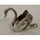 A small silver pin cushion in the form of a swan. Marked 925, with red velvet cushion.