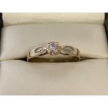 A 9ct gold diamond solitaire ring with detail to shoulders. Stone size approx. 0.07ct.
