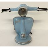 A novelty table lamp in the shape of the handlebars of a Vespa scooter, in pale blue.