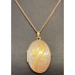 A boxed 9ct gold oval locket with floral engraving to front on an 18" fine curb chain.