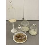 4 white painted metal ornamental garden bird cages in varying shapes and sizes.