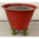 A vintage metal planter/copper, painted red on 3 cabriole style legs painted green.