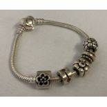 A Pandora charm bracelet with heart shaped clasp and 5 charms.