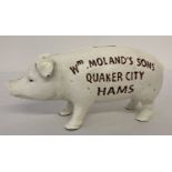 A painted cast iron novelty money box in the shape of a pig.