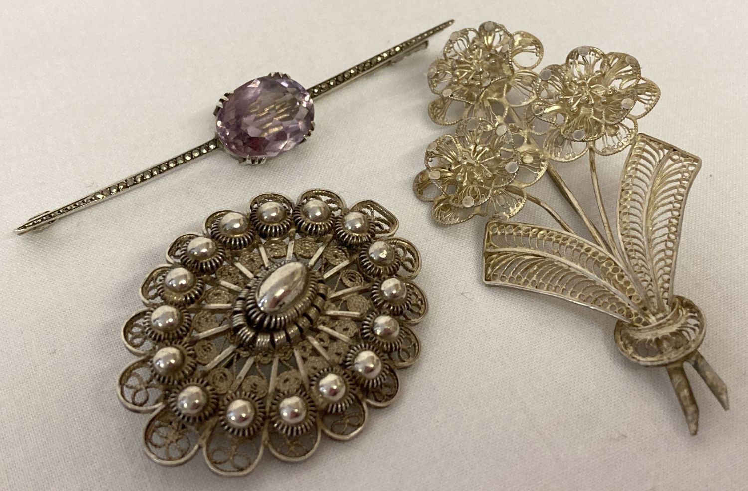 3 vintage white metal brooches. An Art Nouveau bar brooch set with amethyst and marcasite's.