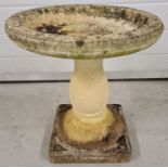 An ornamental concrete garden bird bath on pedestal stand.