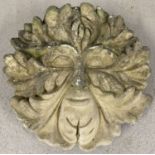 A concrete Green Man wall hanging garden ornament.