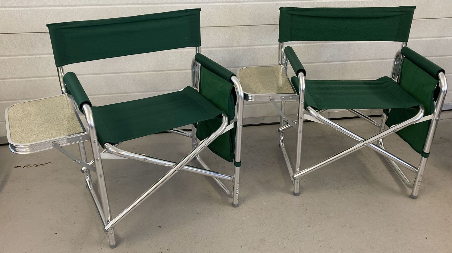 2 modern aluminium framed picnic chairs with green material backs and seats.