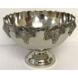 A large silver plated punch bowl with bunches of grapes detailed to rim of outer bowl.