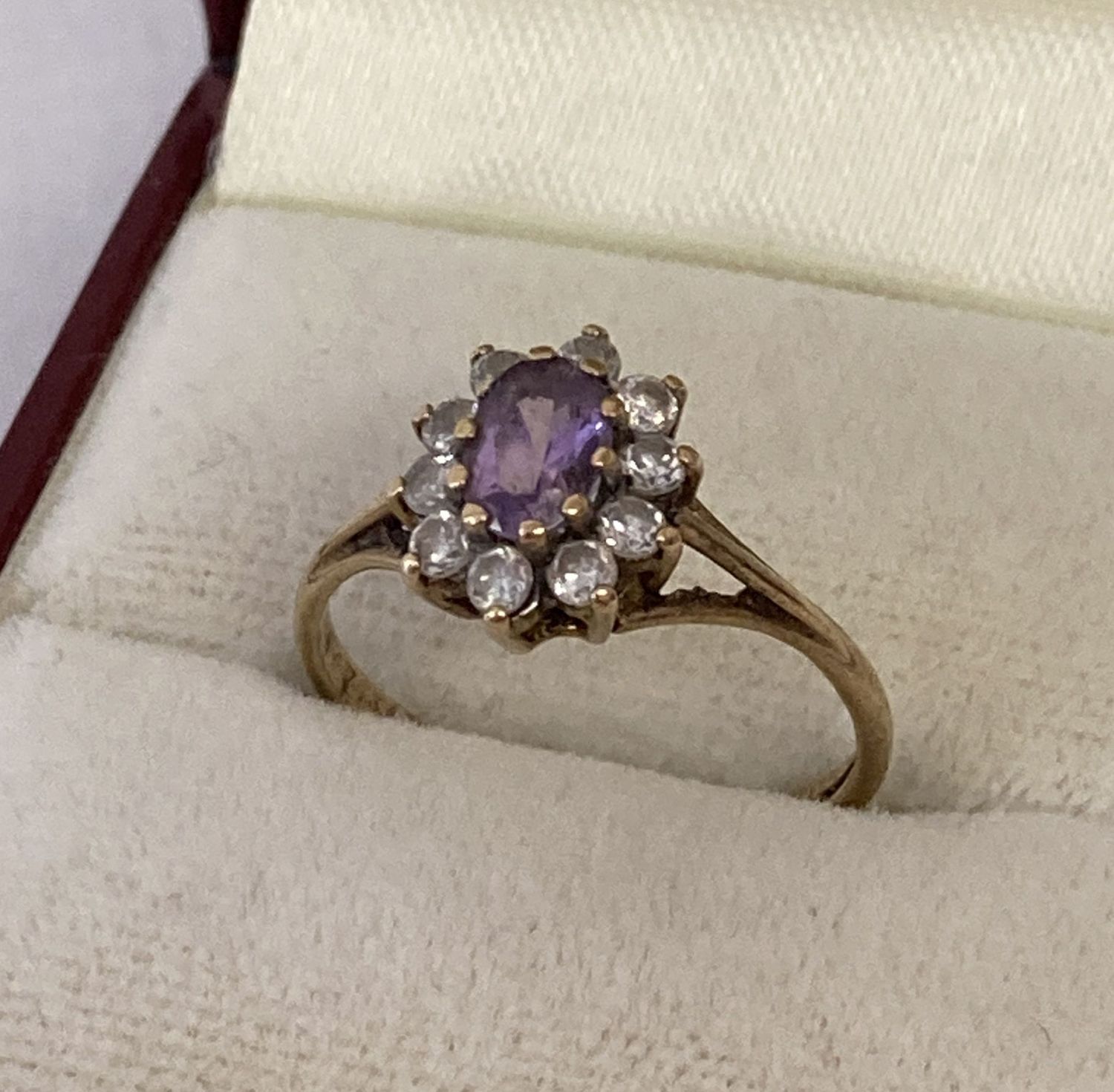 A 9ct gold dress ring set with central oval purple cubic zirconia.