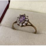 A 9ct gold dress ring set with central oval purple cubic zirconia.