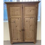 A slimline 2 door pine cabinet with bun style handles and feet. 3 adjustable shelves to interior.
