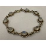 A modern silver bracelet set with 8 oval cut cabochon moonstones. Lobster style clasp marked 925.