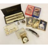 A collection of assorted misc. items to include boxed vest pocket compass, pen set, playing cards,