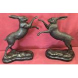 A pair of bronze "boxing hares" figurines mounted on marble bases.