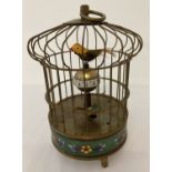 An ornamental wind up birdcage clock with cloisonné panel to base.