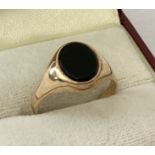 A 9ct gold signet ring set with an oval onyx stone. Full hallmarks to inside of band.