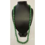 A 32" apple green jade beaded necklace, knotted between each bead.