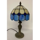 A small Tiffany style table lamp with blue and cream leaded glass lightshade.