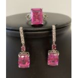 A matching silver dress ring and drop style earrings set with coated pink quartz and clear stones.