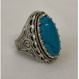 A large white metal and turquoise dress ring.