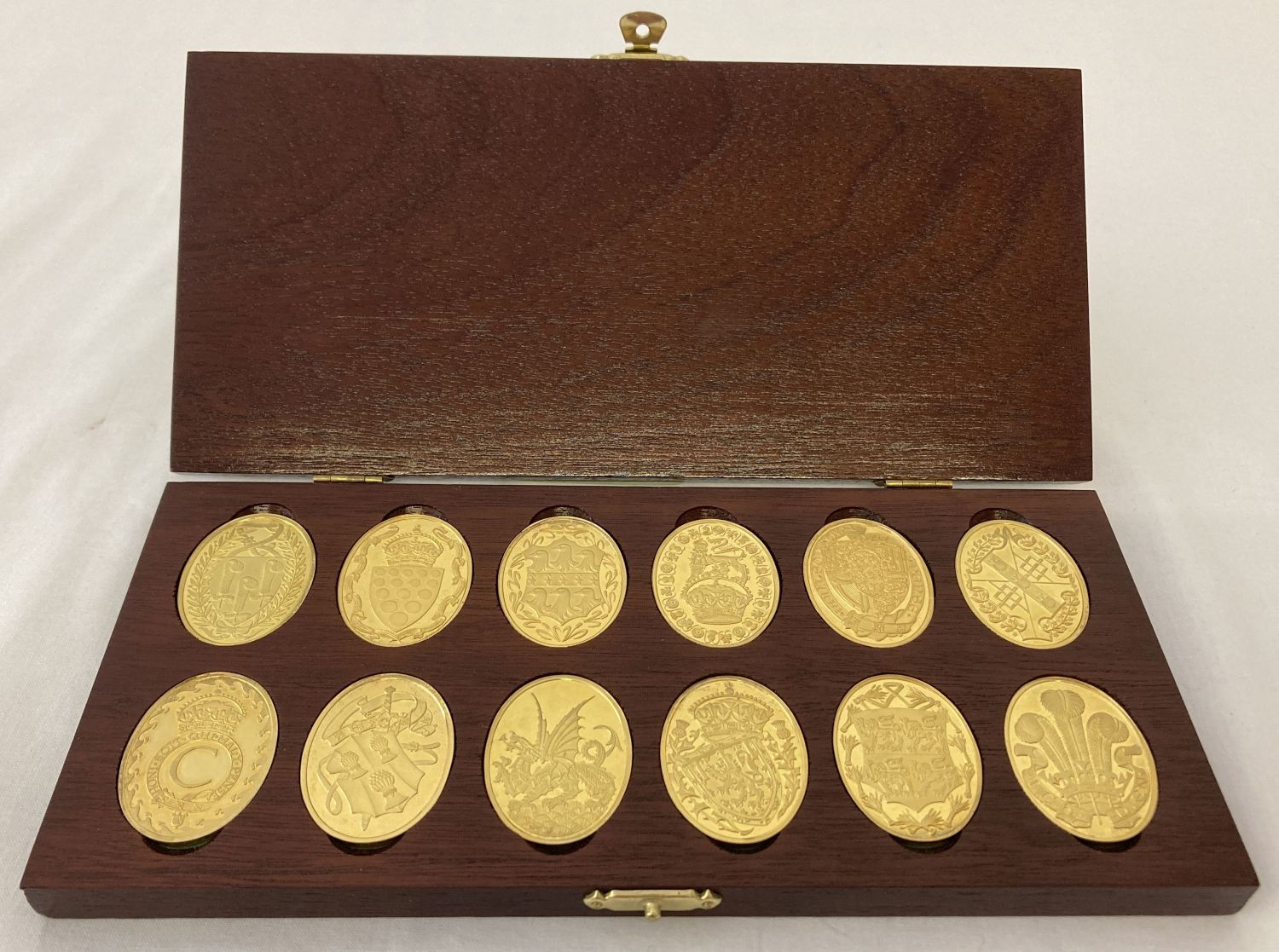A collection of 12 "The Arms Of The Prince And Princess Of Wales" gold plated silver ingots.