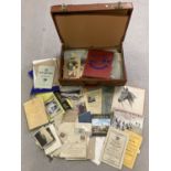 A case containing a quantity of vintage mixed ephemera. To include Gymkhana programmes, postcards,