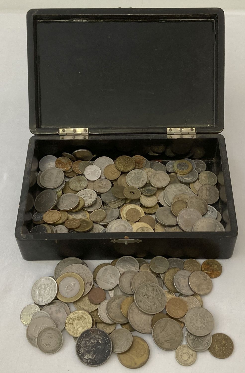 A lacquered box contain a collection of British and foreign coins.