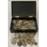 A lacquered box contain a collection of British and foreign coins.