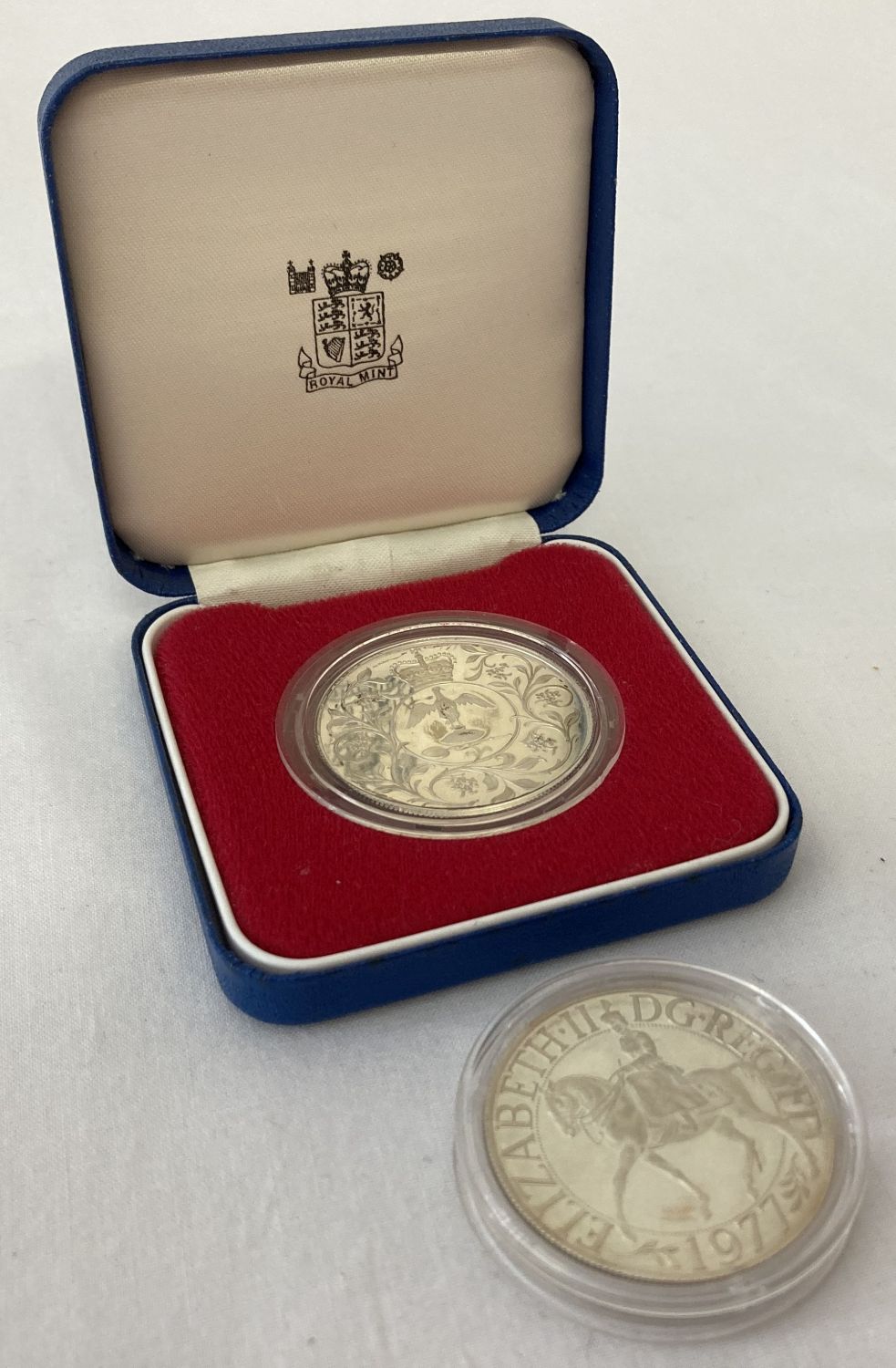 2 x 1977 Jubilee silver crown coins. One in clear base and boxed the other in clear case.