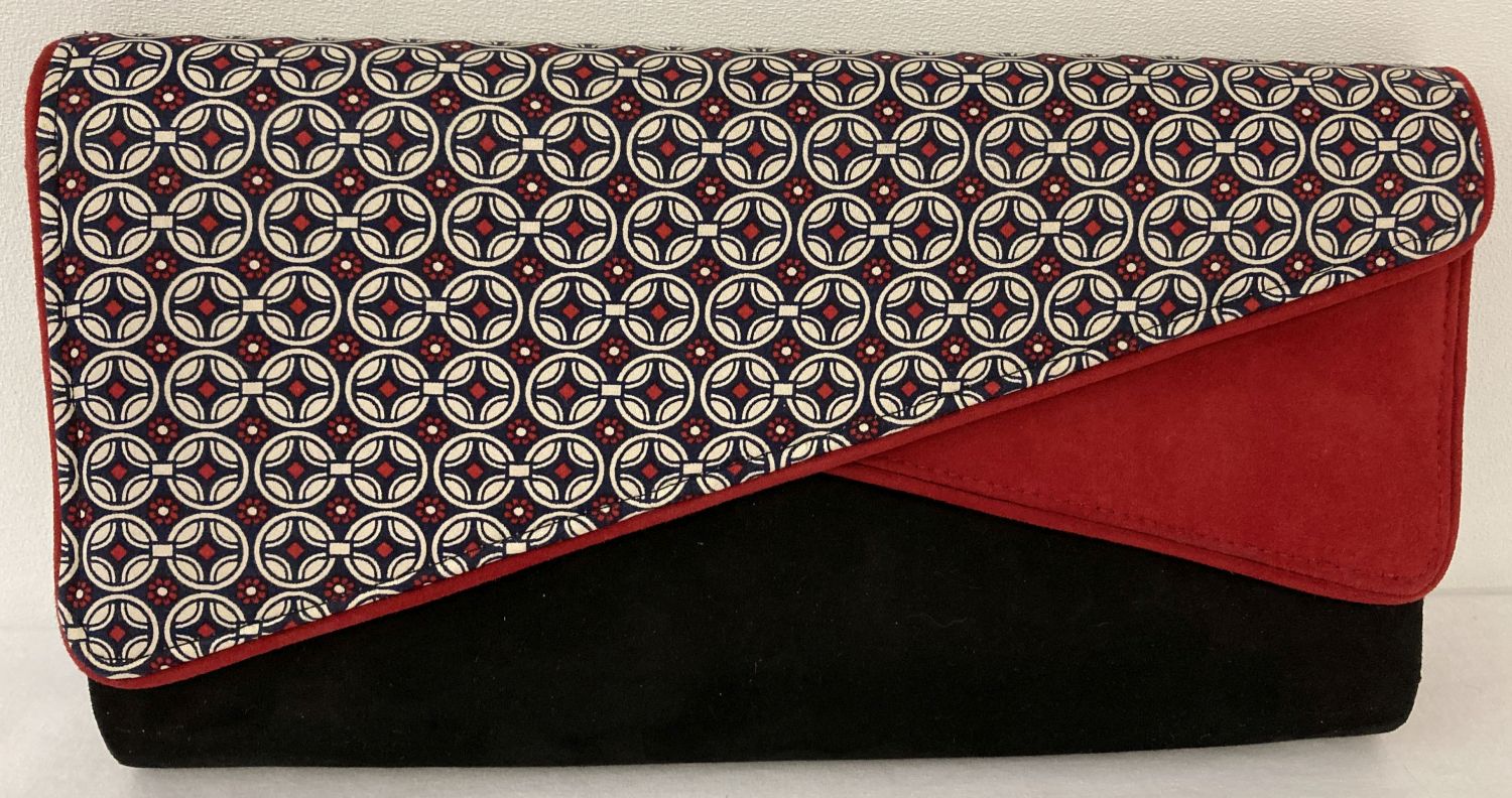 A Ruby Shoo faux suede clutch/shoulder bag in red, black and geometric print.