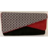 A Ruby Shoo faux suede clutch/shoulder bag in red, black and geometric print.