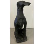 A large concrete figure of a greyhound dog, painted black.