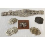 A collection of vintage silver plated nurses belt buckles together with a belt.
