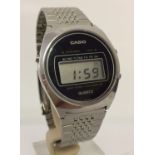 A vintage 1976 Casio watch with stainless steel strap and digital display.