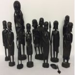 A collection of 10 carved African hardwood figurines with weapons.