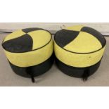 A pair of circular retro black and yellow vinyl foot stools/ pouffes.