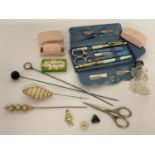 A collection of vintage ladies vanity items to include hat pins, nymph razors and manicure set.