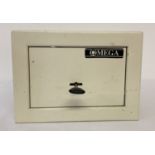 A small white metal Omega safe with key.