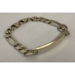 A heavy silver curb chain identity bracelet with empty cartouche and lobster style clasp.