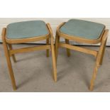 A pair of vintage wooden kitchen stools with vinyl seats.