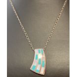 A modern design drop pendant set with white shell and turquoise on a 18" fine belcher chain.