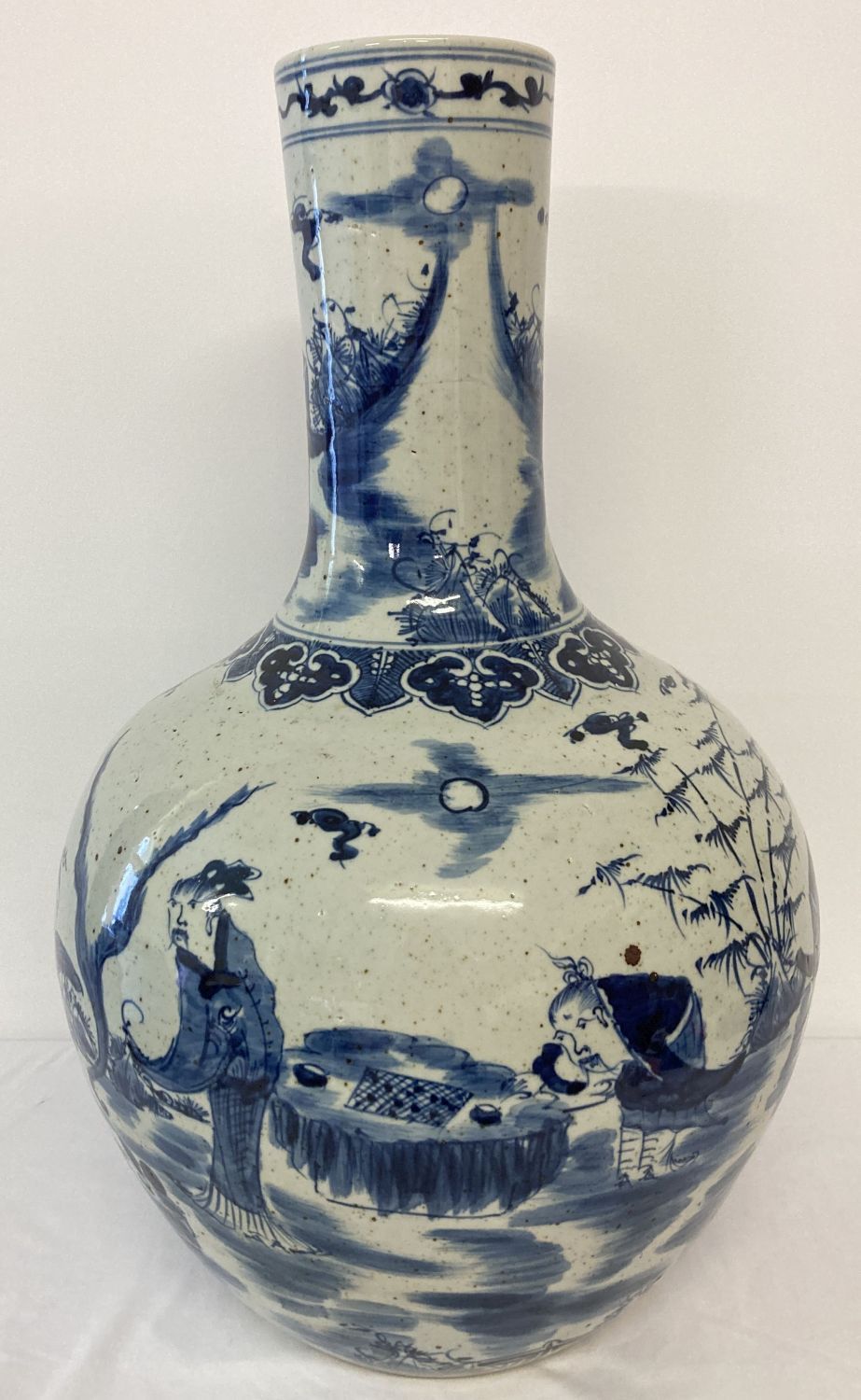 A very large ceramic, hand painted blue and white vase with figural and scenic design.