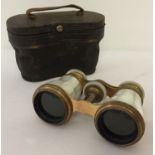 A pair of antique brass and mother of pearl opera glasses in leather case.