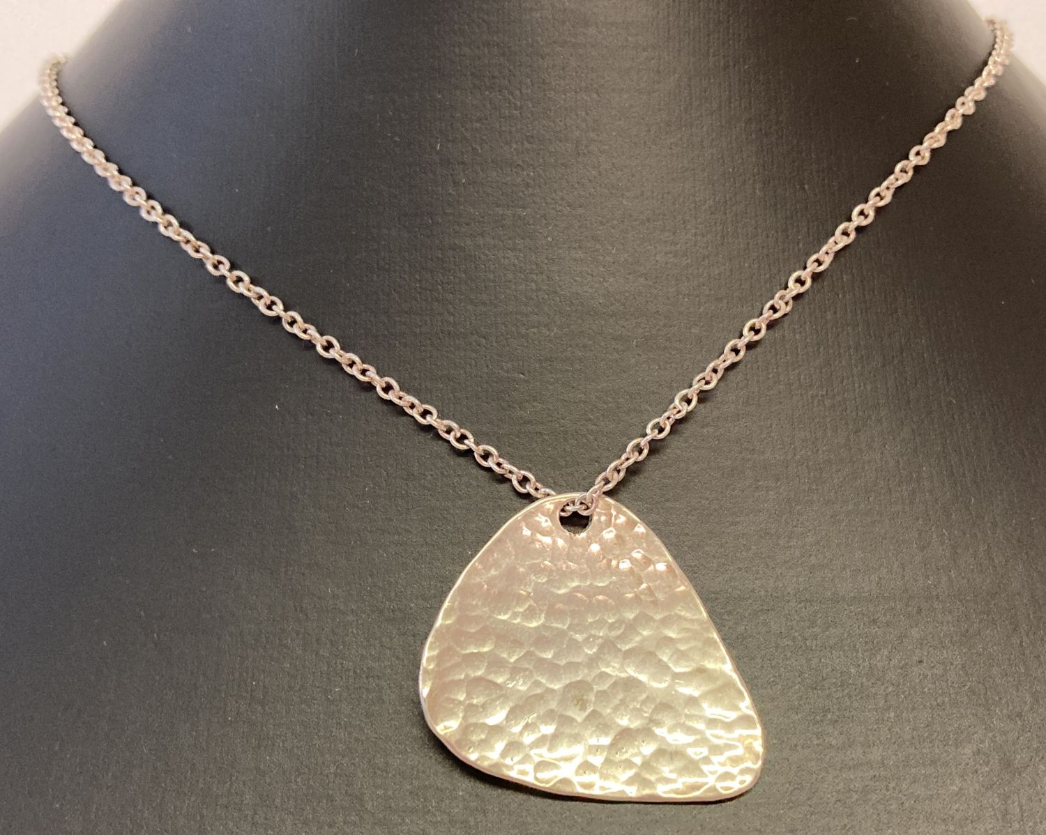 A contemporary design silver pendant with hammered effect detail on a 18" fine belcher chain.