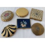 A collection of 6 vintage compacts by Kigu. In varying shapes and designs.