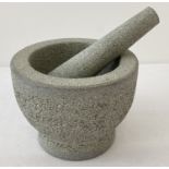 A modern heavy granite pestle and mortar.